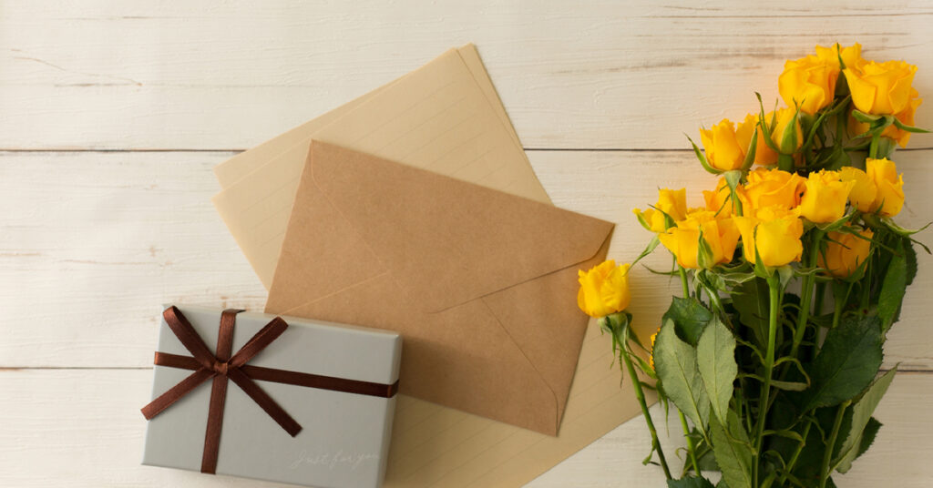 春の新生活応援ギフト プレゼントボックスと茶封筒と手紙のセットと黄色いバラの花束