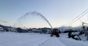 トラクターにスノーラッセルを取り付けて除雪作業